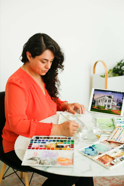 Arielle Vicaria, Senior Graphic Designer & Watercolor Artist, at work on a custom illustration Photography: Yanire Yaniz Photography